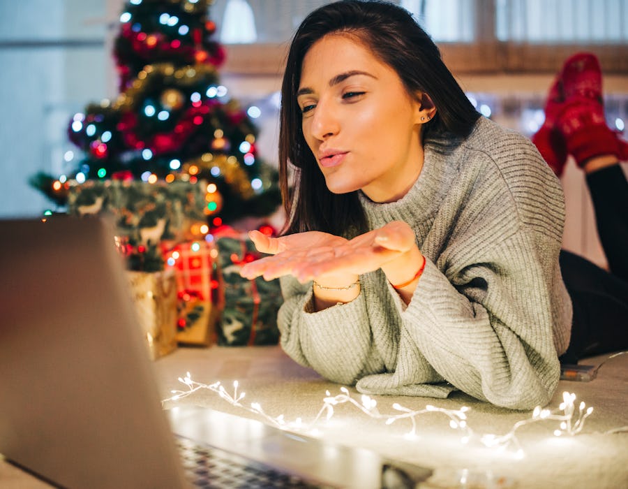 A woman in a long-distance relationship sending a kiss over a call on new year's eve