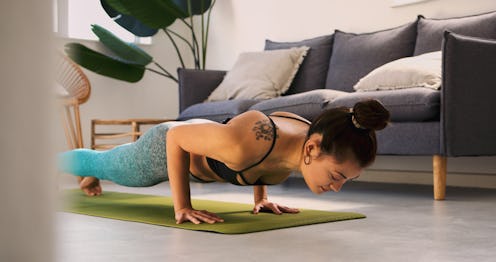 A woman does pushups in her living room. These lightweight workouts you can do anywhere.