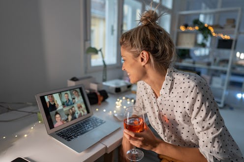 A woman has a glass of wine while on a Zoom call with family. These sneaky things can make hangovers...