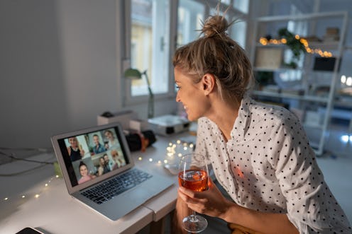 A woman has a glass of wine while on a Zoom call with family. These sneaky things can make hangovers...