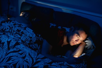 man on cell phone in bed