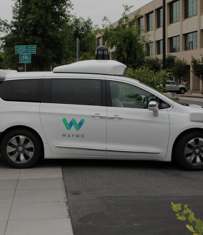 A Waymo autonomous van entering a parking lot. 