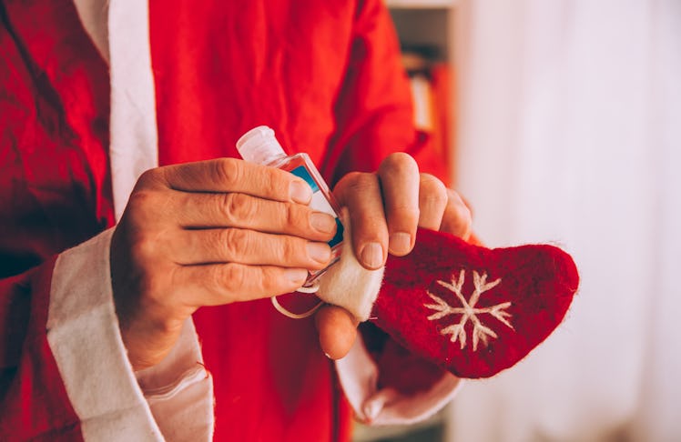 A man is filling his stocking stuffer with a handy and sweet smelling holiday hand sanitizer 