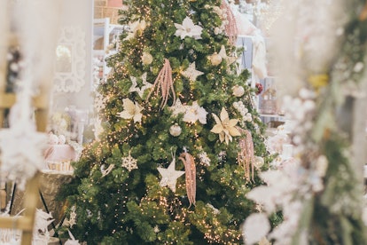 A traditional christmas tree that has flowers as decorations 