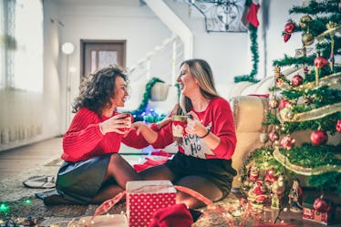 Two friends cheers their mugs of hot chocolate on Christmas.