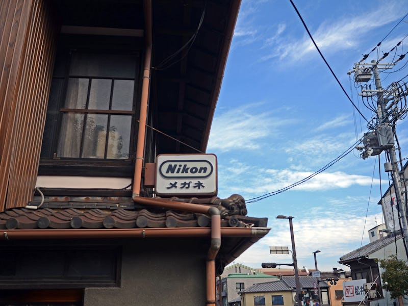 Nikon sign resting on a building in Japan.