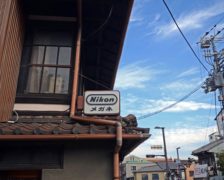 Nikon sign resting on a building in Japan.