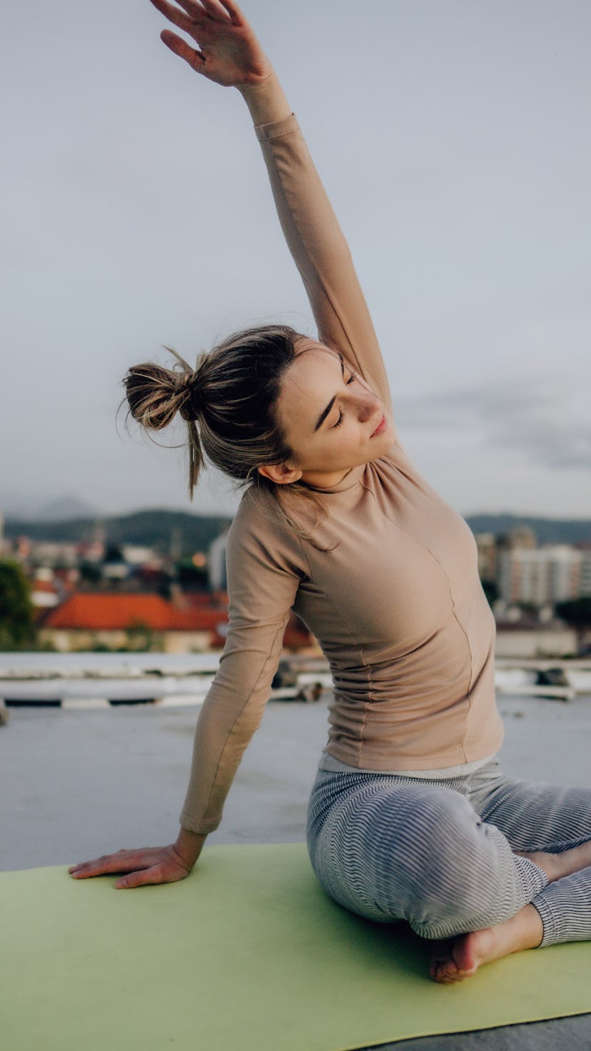 A woman does yoga on a roof. A ClassPass report reveals the most popular virtual workouts of 2020.
