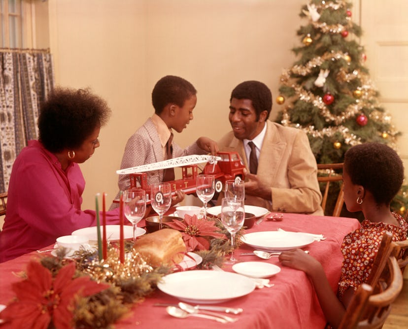 This vintage Christmas photo shows a family at their dining table. 