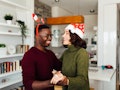 A happy couple dances in their home while listening to TikTok's 2020 Christmas songs.