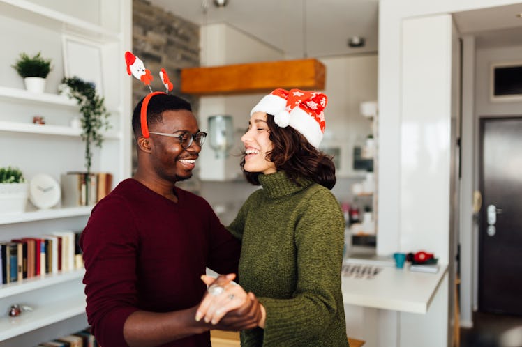 A happy couple dances in their home while listening to TikTok's 2020 Christmas songs.
