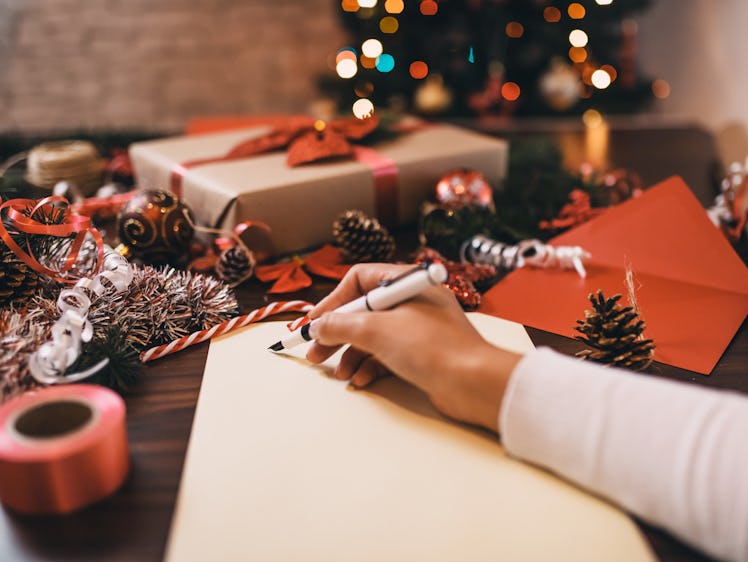 A woman wraps gifts and makes holiday crafts at home. 