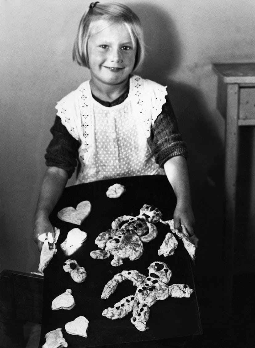 This vintage Christmas photo features a girl with Christmas cookies. 