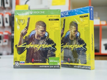 Two packs of Cyberpunk 2077 are seen on a white countertop. The games are still sealed and possibly ...