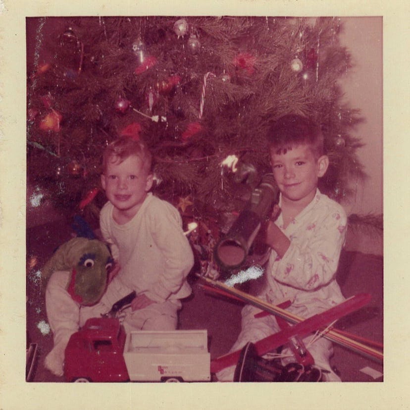 This vintage Christmas photo shows two brothers opening gifts. 