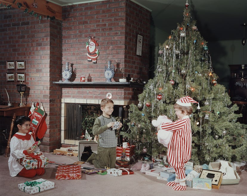 Playing in front of the tree is a classic scene in this vintage Christmas photo. 
