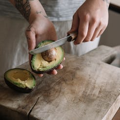 A woman cuts an avocado after a new study found that avocado can help your gut health.