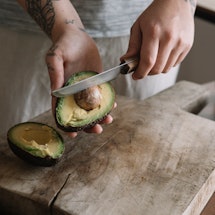 A woman cuts an avocado after a new study found that avocado can help your gut health.