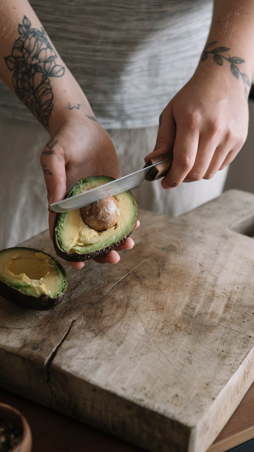 A woman cuts an avocado after a new study found that avocado can help your gut health.