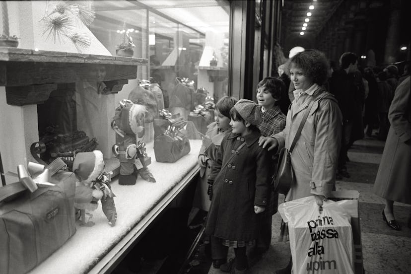 This vintage Christmas photo shows a mom and kids window shopping. 