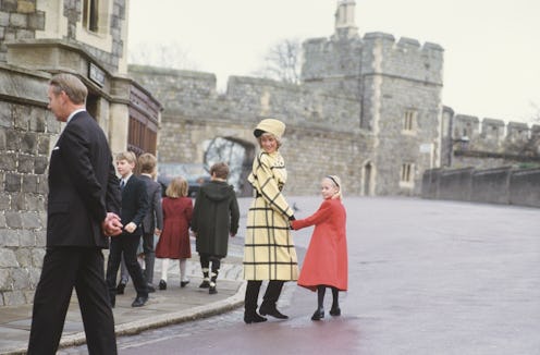 Princess Diana in a stylish festive look for Christmas day, holding a hand of a girl wearing a red c...