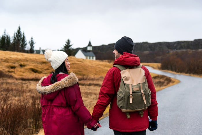 couple holding hands on road