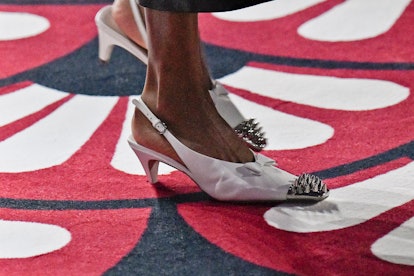 a model on the runway wearing white slingback studded kitten heels, a retro shoe trend for 2021