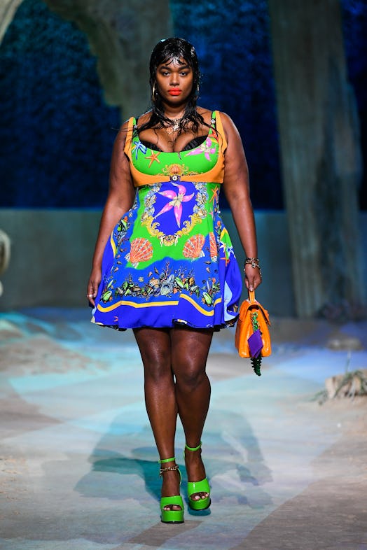 A plus size model wears lime green platform heels on the runway, showcasing a major 2021 shoe trend