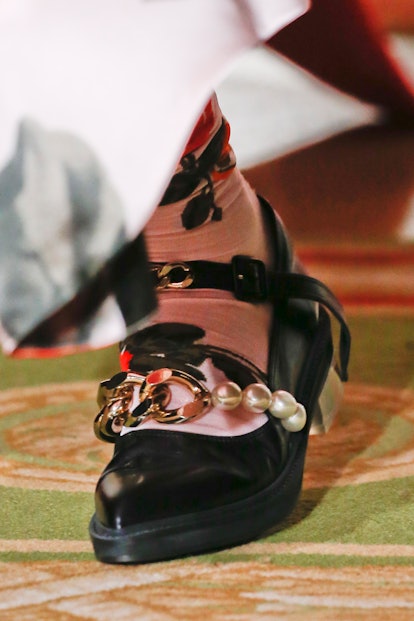A model wearing a black ballet flat shoe on the runway, demonstrating a 2021 shoe trend