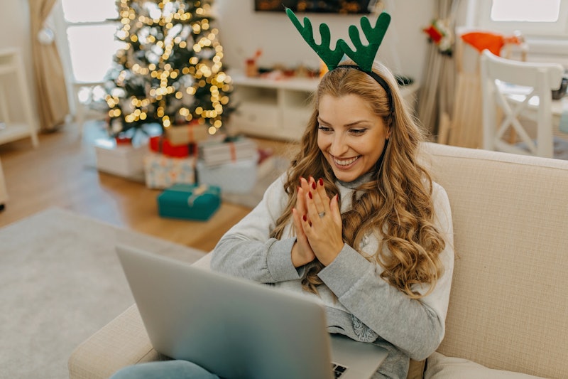 A woman wearing reindeer ears at her computer contemplates the mental health benefits of being in th...