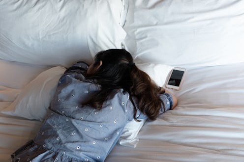 A woman lies in bed on her stomach. COVID cases can last so long potentially because of overactive i...