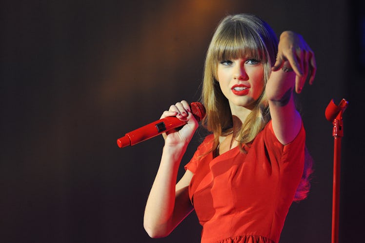 Taylor Swift performs a holiday concert in a red dress and matching microphone, complete with a her ...