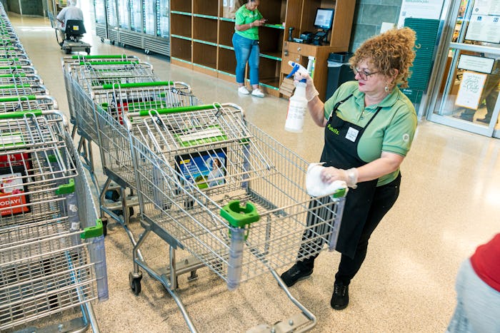 employee spraying carts at publix