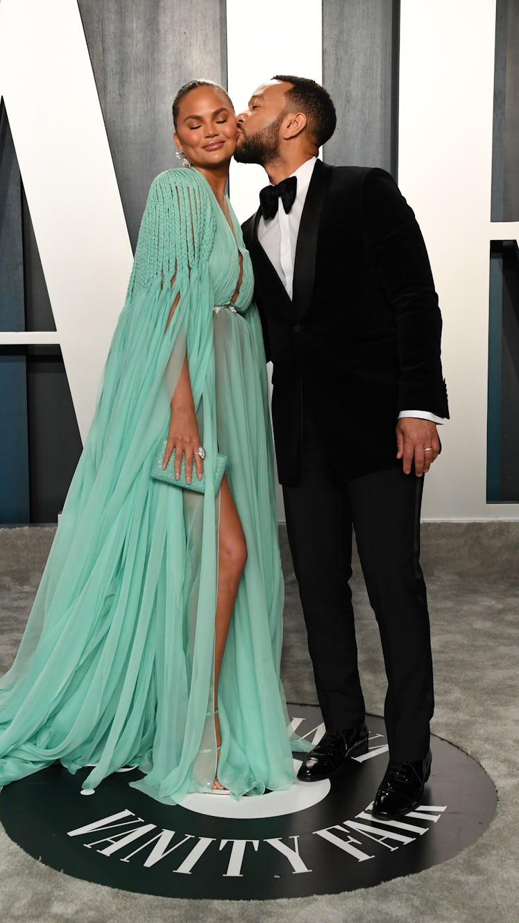John Legend kissing Chrissy Teigen on the cheek at the 2020 Vanity Fair Oscars Party