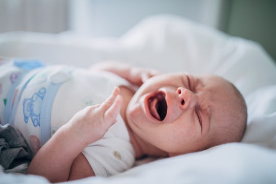 a baby crying on a bed