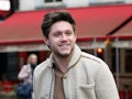 Niall Horan steps out in a cream-colored sweater and grey slacks. 