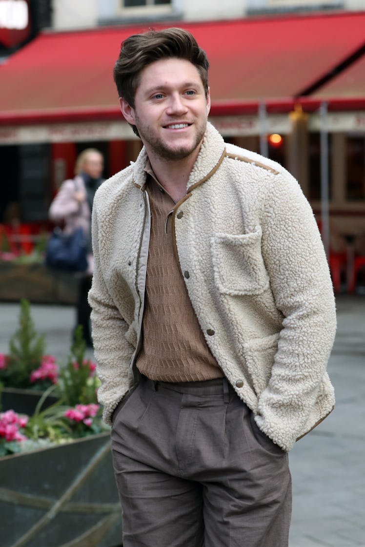 Niall Horan steps out in a cream-colored sweater and grey slacks.