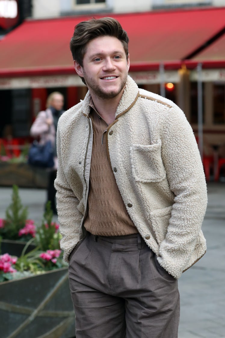 Niall Horan steps out in a cream-colored sweater and grey slacks. 