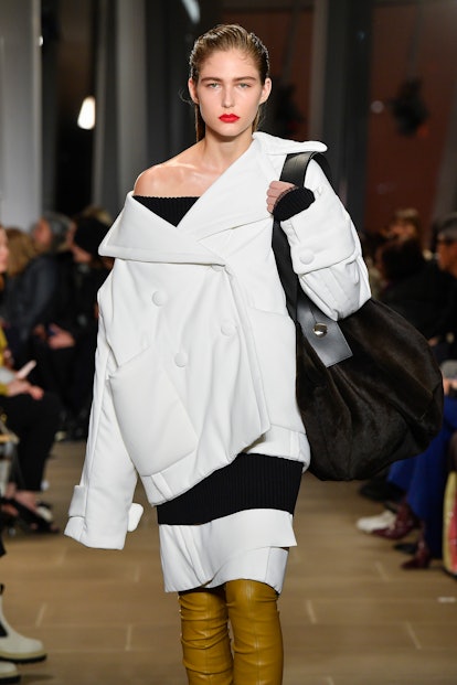 A model on Proenza Schouler's Fall/Winter 2020 Runway wearing a white double-breasted jacket that sl...