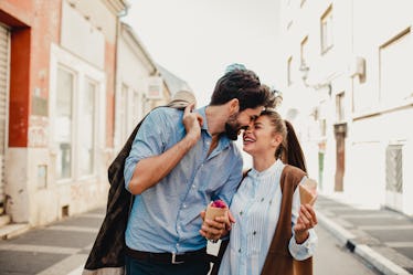 A couple shares a sweet moment while on a romantic trip and holding ice cream cones. 