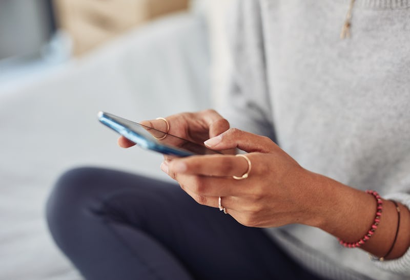 A woman sits cross legged, texting a friend. Social media can help form community around mental heal...