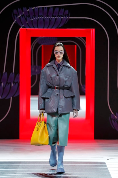 A model walking the Prada Fall 2020 runway in a grey leather puffer coat 