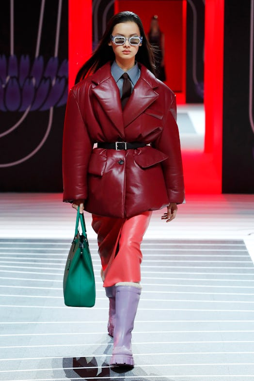A model walking the Prada Fall 2020 runway in a maroon leather puffer coat