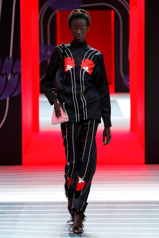 A model walking the Prada Fall 2020 runway in a stripy black and white set with red flowers 