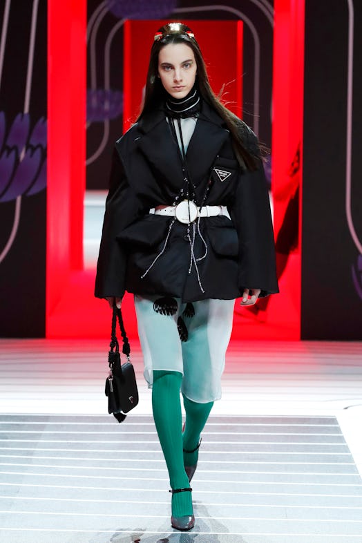 A model walking the Prada Fall 2020 runway in a belted black puffer coat 