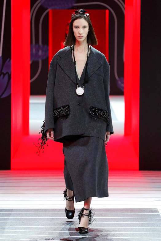 A model walking the Prada Fall 2020 runway in an oversized grey blazer and matching skirt 