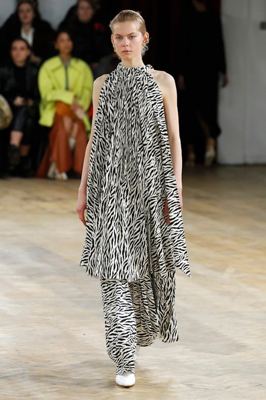 A model walking the runway in a zebra print tunic and matching pants