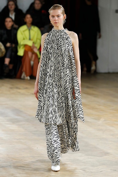 A model walking the runway in a zebra print tunic and matching pants
