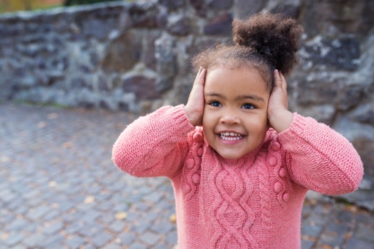 toddler girl covering her ears