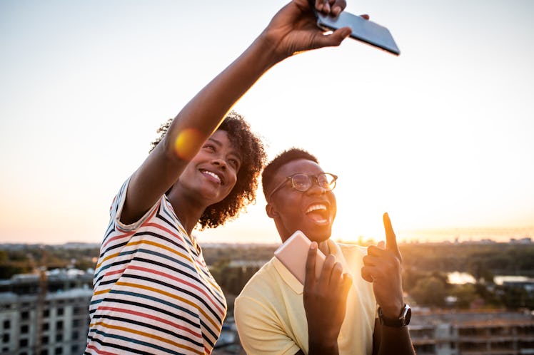 A young couple poses for a selfie before leaving a cute comment on their partner's Instagrams.